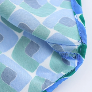Macro du tissu à imprimé géométrique avec couture bleue et finition de bordure de haute qualité