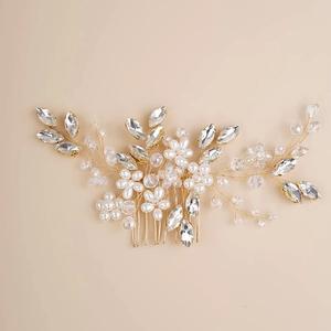 Detailed close-up of handmade bridal hair comb with gold wire, pearls and crystals