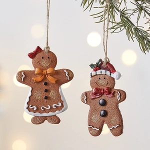 Charming gingerbread man and woman ornaments hanging on a festive Christmas tree