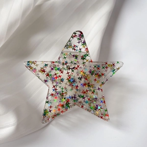 Dettaglio della pinza per capelli a stella in acetato con glitter colorati vivaci