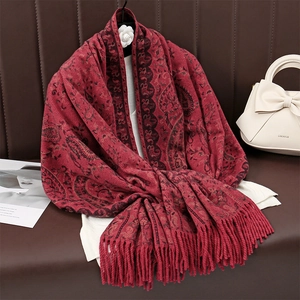 Elegant red cashmere-feel scarf with paisley patterns and tassels on leather background