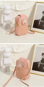 Detail of pink quilted crossbody bag with white rabbit buckle and gold zipper
