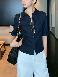Détail de la texture d'une chemise en lin bleu foncé avec boutonnage simple sur modèle