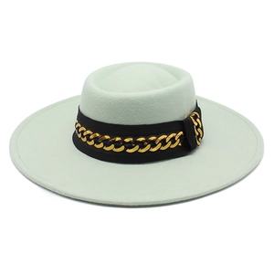Close-up of mint green wool fedora hat featuring a black ribbon and gold chain detail
