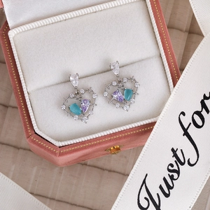 Exquisite heart-shaped silver earrings with purple and blue teardrop stones in a gift box