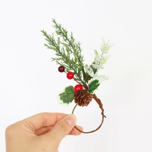 Rond de serviette de Noël avec aiguilles de pin, baies rouges et pomme de pin décorative