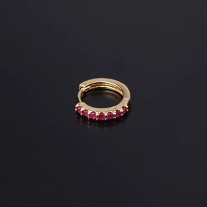 Detailed macro view of golden hinged hoop earring set with round pink zircon stones