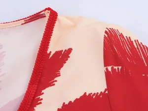Detail of V-neck collar with red braided trim on beige Hawaiian palm print dress