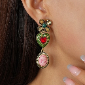 Retro baroque earrings with flower and portrait charms shown on a model