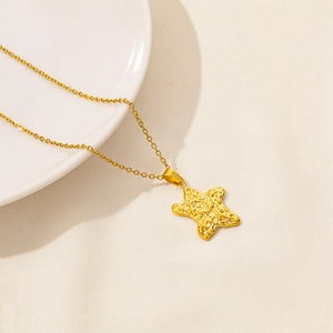 Detailed close-up of a gold starfish pendant with a unique hammered metal texture