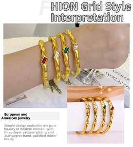 Detail of four stackable gold wave bracelets with multicolored cubic zirconia stones