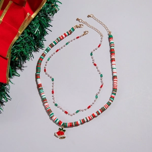 Close-up of festive double-layer Christmas necklace with red green beads and bell charm