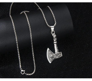 Detailed close-up of retro stainless steel Viking axe pendant with engraved textures