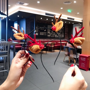 Detail of plush Christmas reindeer antlers and red polka dot balls on holiday headbands