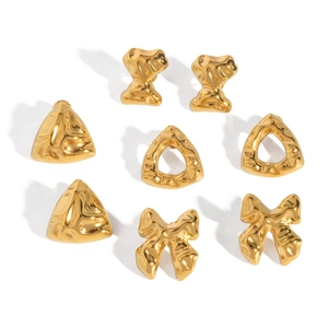 Detail von vier Paaren goldener Ohrringe mit X-, Dreiecks- und Schleifendesigns