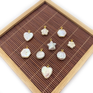 Baroque natural freshwater pearl pendants in heart and star shapes on a bamboo tray