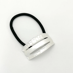 Detailed macro view of white curved hair ring with pearl luster texture and black band