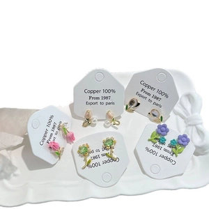 Elegant flower stud earrings set with pink tulips and pearls on a white tray