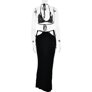 Vista posteriore di un set in maglia nera con top all'americana e gonna lunga traforata