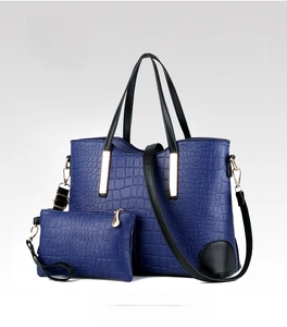 Macro detail of dark blue crocodile pattern tote bag with matching coin purse and gold hardware