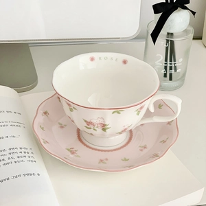 Detail of pink floral ceramic coffee cup and saucer set with Rose lettering inside