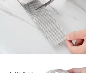 Macro detail of cutting grey fiberglass mesh screen repair tape with strong adhesive