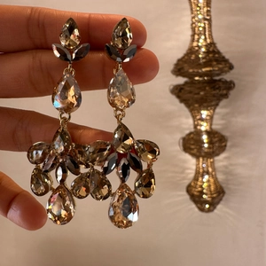 Macro shot of luxurious champagne teardrop crystal earrings with elegant gold-plated frame