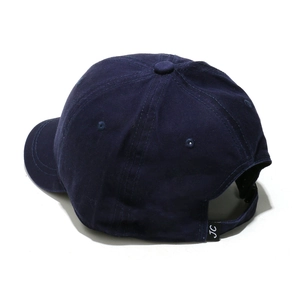 Detail of adjustable strap with JC woven label on navy blue cotton baseball cap