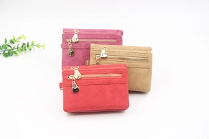 Three stacked PU leather wallets in red and khaki with golden bulb-shaped pendants