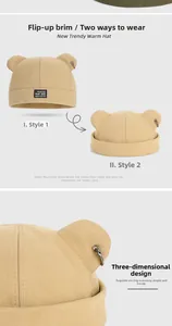 Détail du bonnet en maille beige avec oreilles d'ours mignonnes et breloque anneau argenté