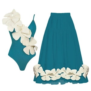 Detail of teal swimsuit with large white 3D flower decoration and matching skirt