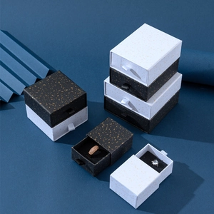 Dettaglio di scatole portagioie a cassetto con macchie dorate e nastri decorativi