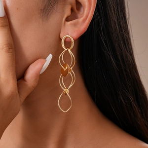 Detailed view of golden multi-layer geometric drop earrings on model for fashion display