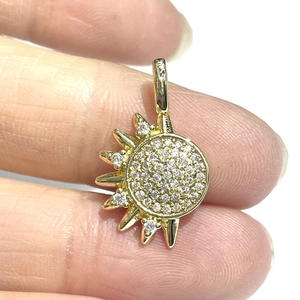 Macro shot of gold sun pendant with cubic zirconia and 925 hallmark engraving