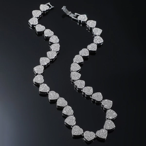 Silver iced-out heart Cuban link necklace with sparkling crystals on black background