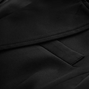 Close-up of the tailored pocket and fine stitching on a slim-fit black blazer jacket