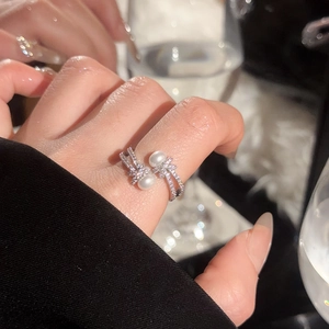 Elegant pearl ring featuring a crystal-encrusted bow on a double-row silver band