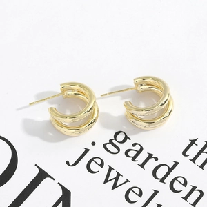 Detailed shot of golden dual-layered hoop earrings on a decorative minimalist card