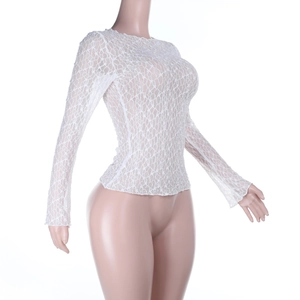 Detalle de top de encaje blanco de manga larga con textura floral semitransparente y cuello