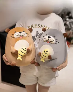 Detailed view of plush otter soft toys in grey and brown holding a small yellow fish