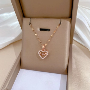 Macro detail of rose gold heart pendant with zircon pavé in a beige jewelry box