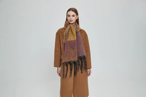 Detail of soft mohair-like scarf featuring wavy patterns and thick tassels decoration