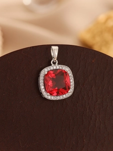 Detailed macro view of a four-prong square red zircon pendant with a halo of clear crystals