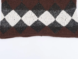 Nahaufnahme von Argyle-Strickgewebe mit weicher Textur und dezenten Silberpailletten
