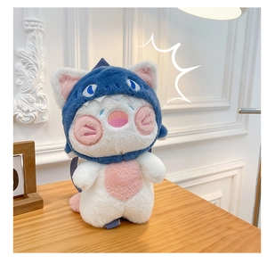 Close-up of white plush cat wearing a blue shark costume with soft fur texture details