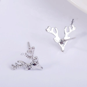 Macro shot of silver reindeer stud earrings with polished metallic finish for Christmas