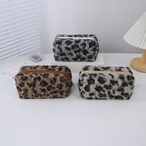Close-up of leopard print plush makeup bags in grey, brown, and beige with soft textures