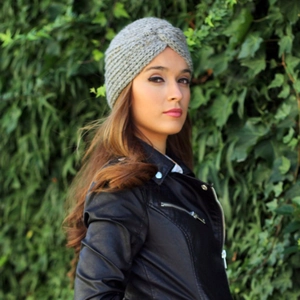 Detail of grey knitted turban hat with cross pleated design and warm winter texture