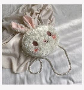 Close-up of white plush bunny bag with pink ears and delicate pearl chain strap