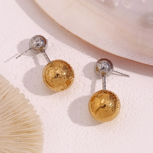 Detail von zweifarbigen Gold- und Silbermetallkugel-Ohrringen mit spiegelndem Finish